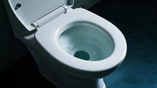 What causes the water level in the toilet bowl to lower?