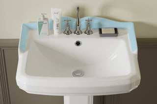 a pedestal sink with ample space and a back panel